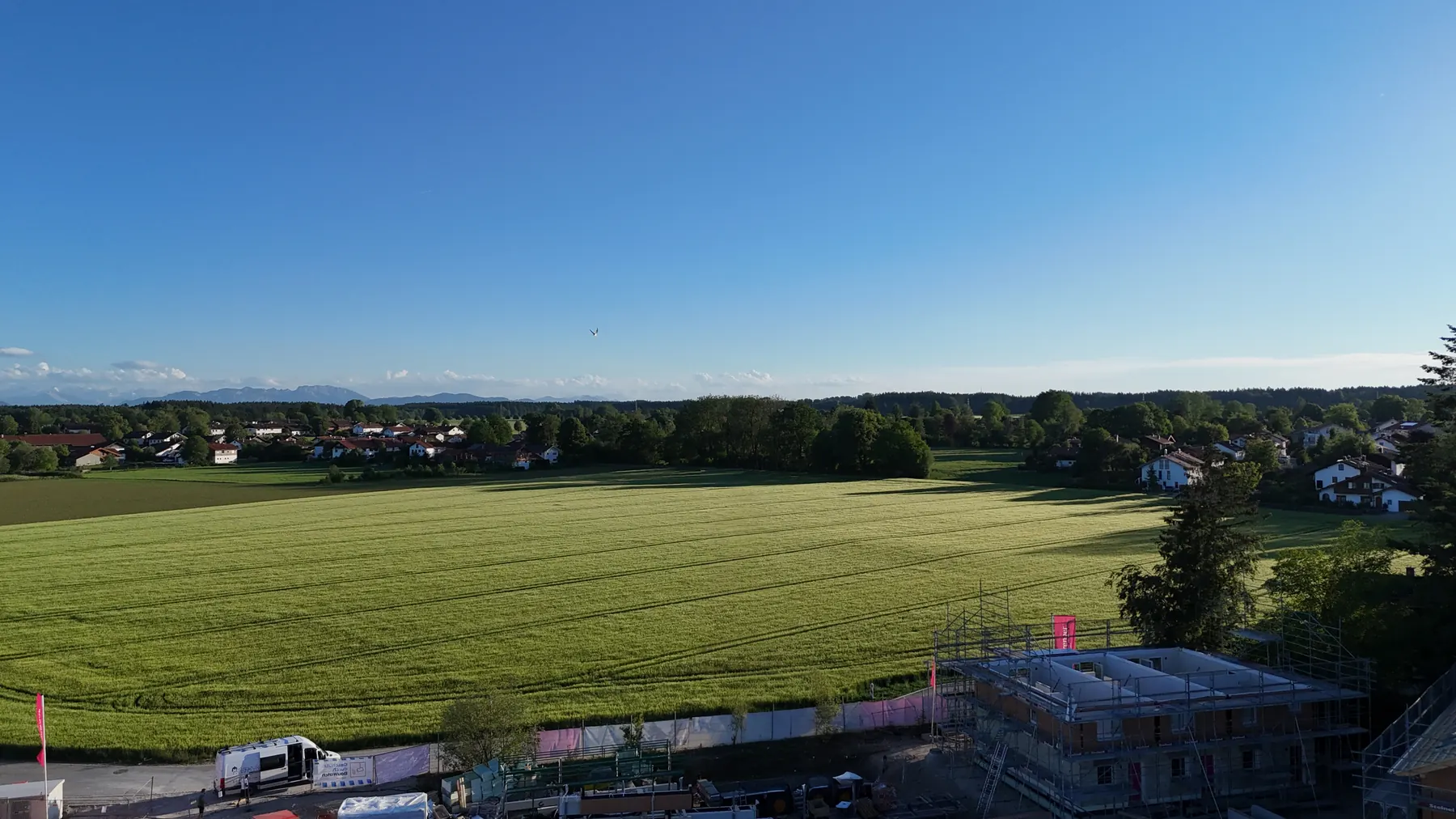 Blick vom Baufeld über die Felder bei Otterfing Richtung Alpen